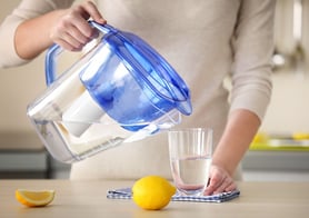 bigstock-Woman-pouring-water-from-filte-127328057.jpg